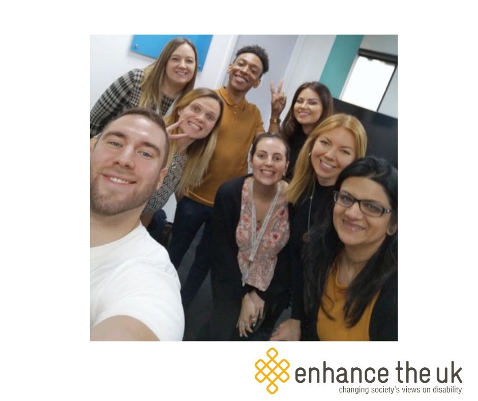 Jennie and Justin delivering disability awareness training to a staff team from Badenoch + Clark. Everyone is smiling at the camera in a selfie pose.