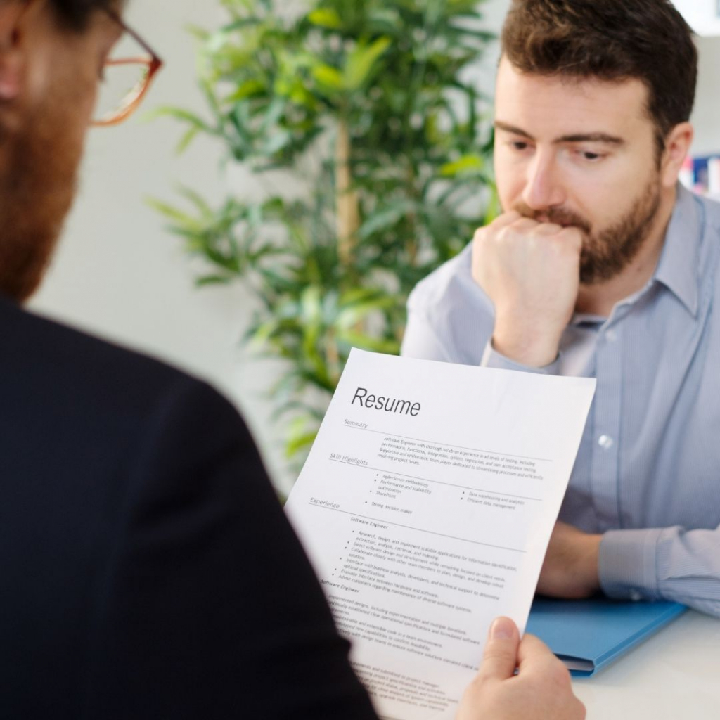 What is a hidden disability? A man in a job interview nervously bites his nails whilst the interviewer reads his CV